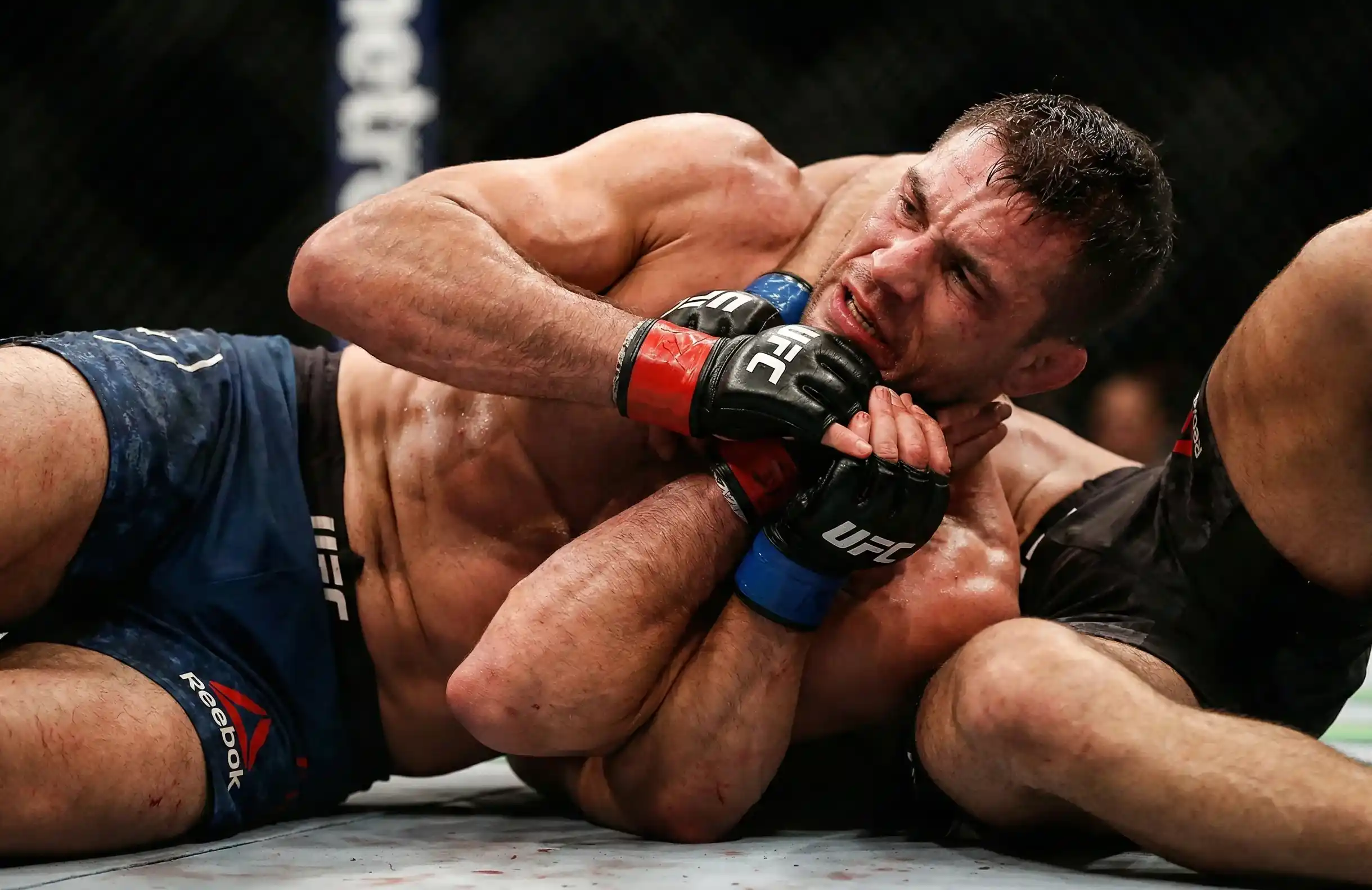 Luchador de UFC defendiendo un intento de sumisión en el suelo